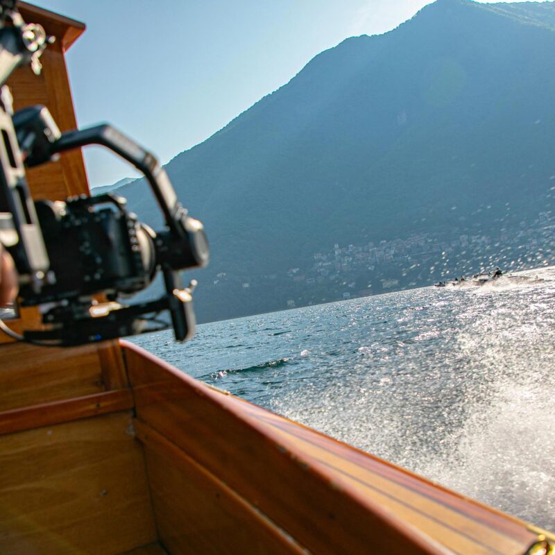 Sony A7S III camera on set during Como Classic Boats filming on Lake Como, Italy — cinematic water spray and historic wooden boats racing in background