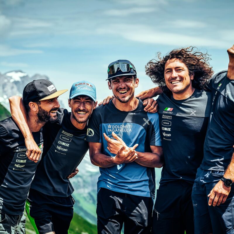 Nicola Donini embracing supporters Marco Recchia, Fiorenzo Graziano, Bernardo Zeni and Marco Diliberto at finish of Red Bull X-Alps 2021 — Vulnerability documentary by Uptelling